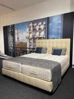 Laden Sie das Bild in den Galerie-Viewer, Treca Paris Boxspringbett Colette Perspektive von rechts mit grauen Kissen und Decke.
